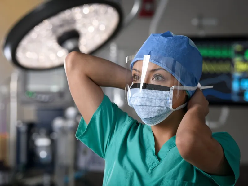 Surgeon putting on mask
