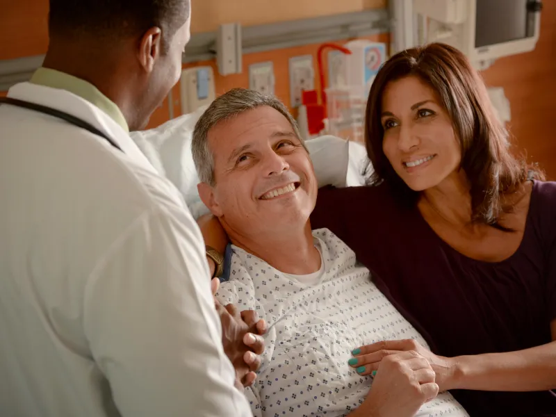 Supportive AdventHealth doctor with patient and caregiver.