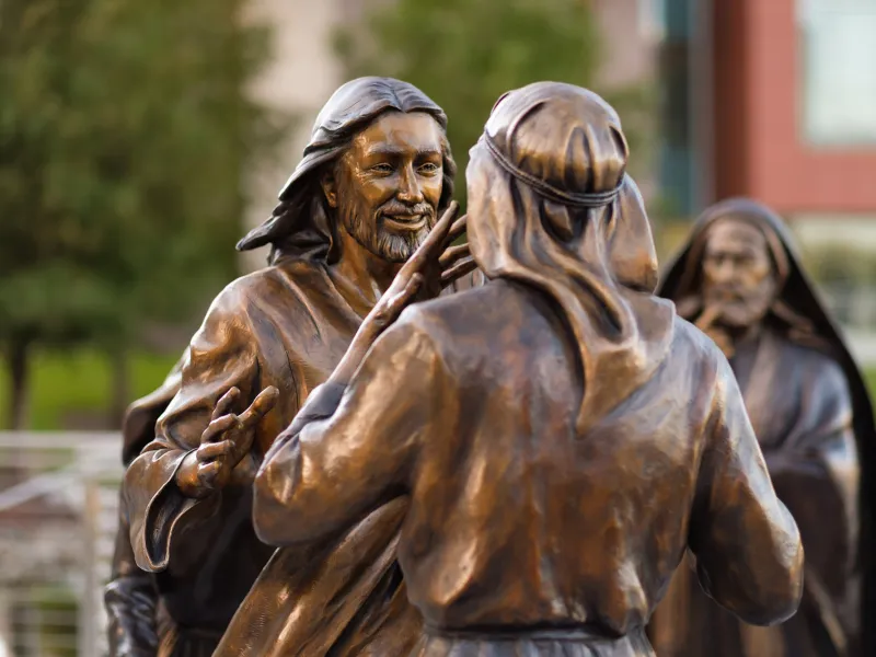 Statue of Jesus approaching a man to heal him.