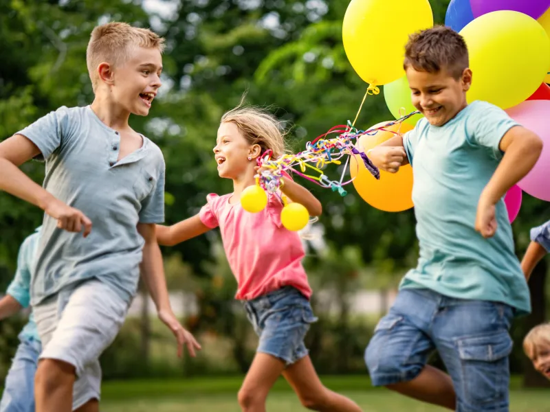 Kids running and playing with balloons