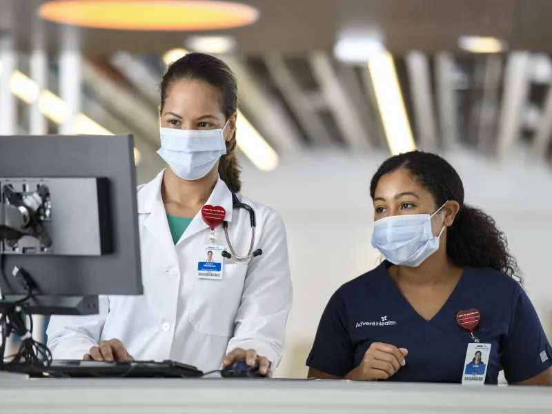 Two female physicians looking at a computer