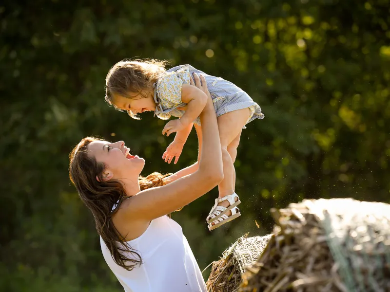 Mother playing with her daughter at the park.