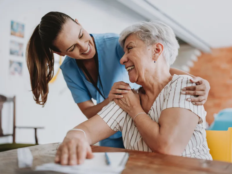 Nurse smiling with senior woman patient.
