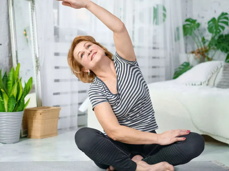 Woman sitting on the floor stretching.