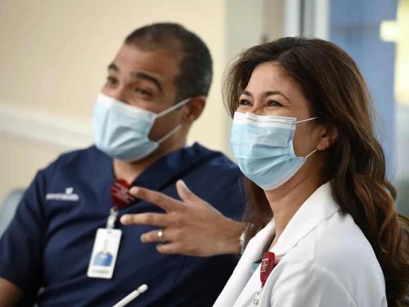 Two physicans wearing masks talking