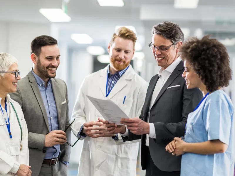Physicians smiling and talking in hospital hallway