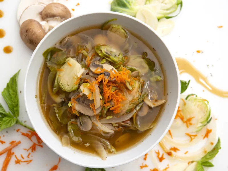 Bowl of Power Greens soup with mushroom and herb garnishes