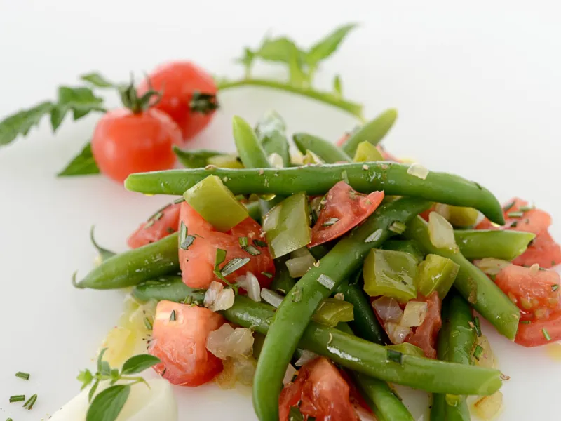 Vegetable dishing including green beans, tomatoes, and peppers