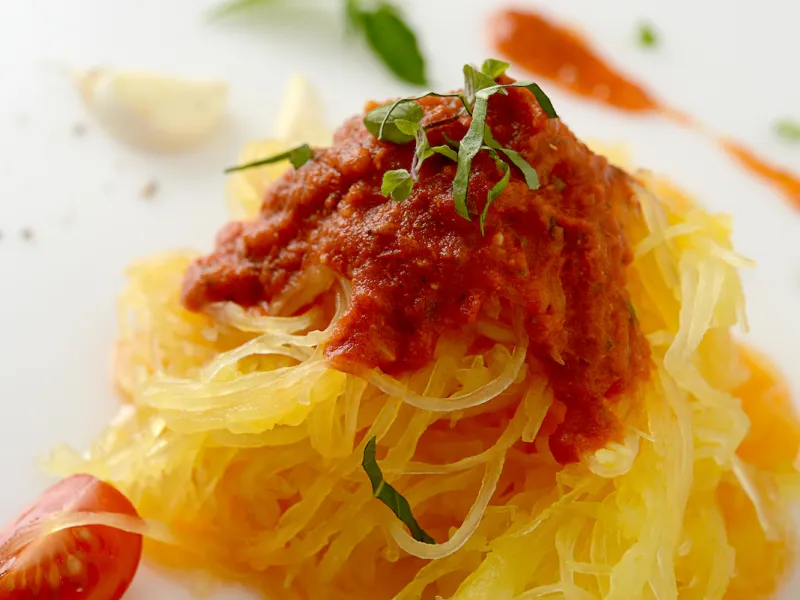 Mound of spaghetti squash topped with marinara and herbs 