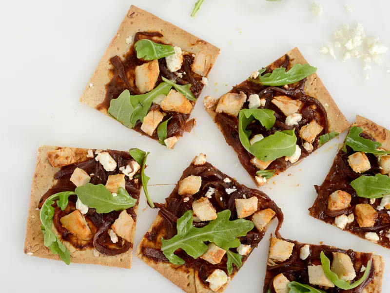 Six squares of chicken flatbread on white counter