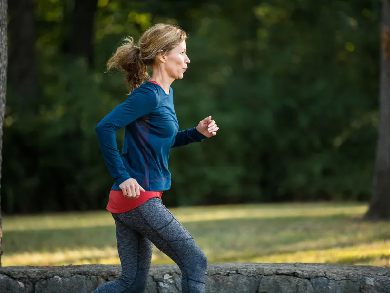 A young woman taking a morning run around in the park.