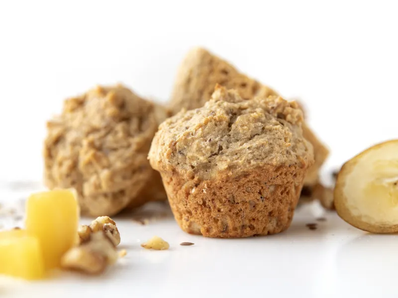 Three muffins with banana and pineapple chunk garnishes