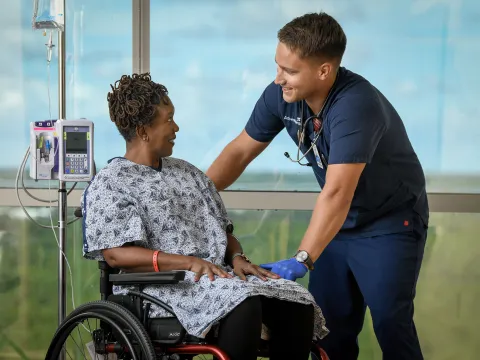 A female patient in a wheelchair with her provider.