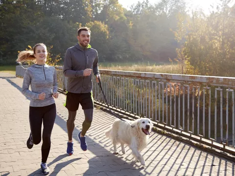 A couple running with their dog