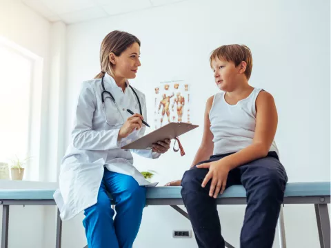 A Doctor Speaks to Her Adolescent Patient in an Exam Room