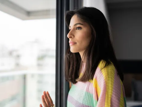 A Woman Stairs Calmly Out an Apartment Window
