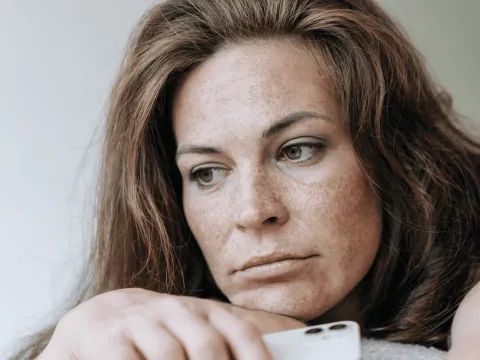 A Woman Rest's Her Head on Her Crossed Arms