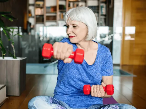 Senior woman doing strength training with weights.