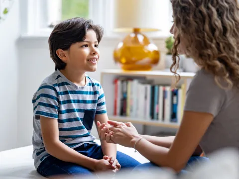 A woman talking to her young son at home.
