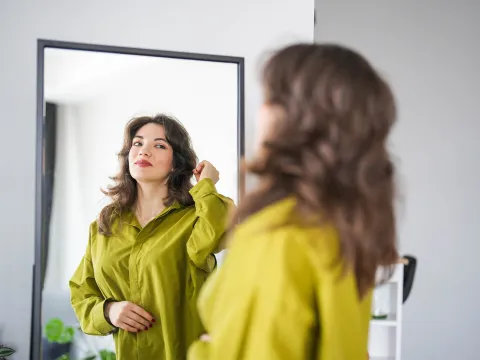 A woman looking at herself in the mirror.