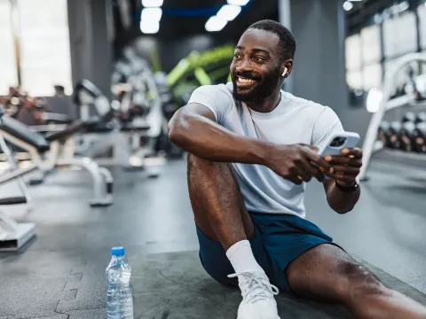 A man taking a break from a workout at the gym.