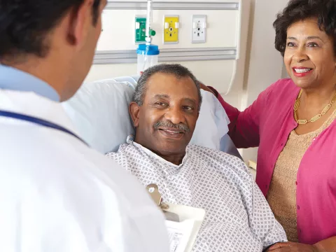 Doctor visiting patient in bed.