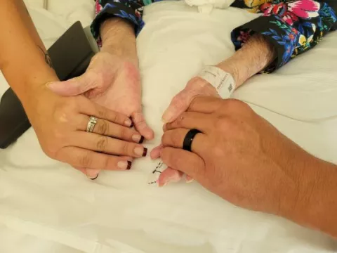 The couple holds hands with their grandmother showing off new wedding rings.