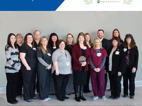 A group of co-workers standing next to each other.