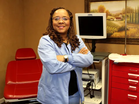 A woman standing in the middle of a consultory.