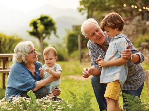Grandparents with grandchildren in garden.