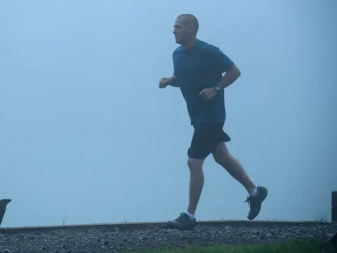 Man out for a jog in the fog.