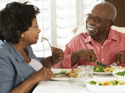 This caregiver eats a diabetic-friendly meal with their loved one.