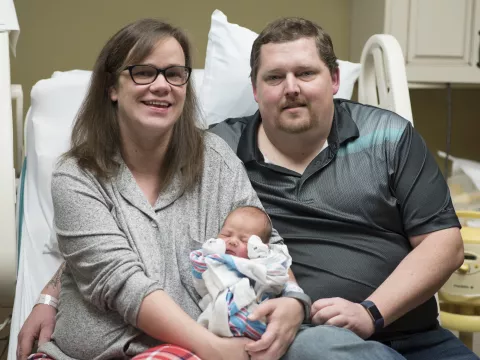 mother and father holding a baby