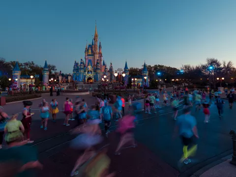 Runners running runDisney event at Magic Kingdom in front of Cinderella's Castle.