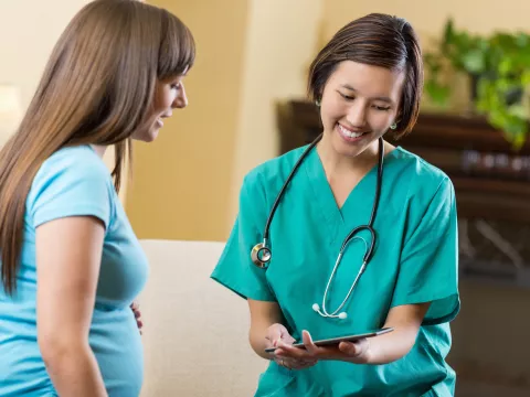 A woman discusses health symptoms with her doctor.