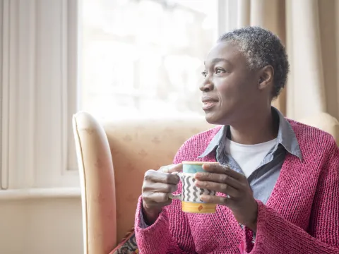 Enjoying her morning coffee, a mature woman reflects on life.