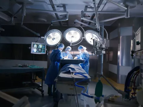 Three Doctors Work on a Patient in an Operating Room