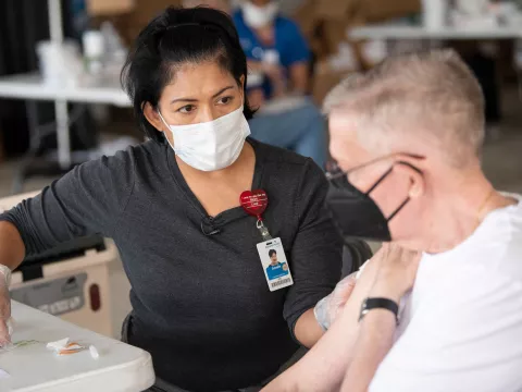 AdventHealth employee talks to an elderly man receiving a coronavirus vaccination