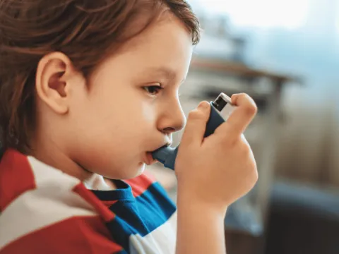 A child using an inhaler.