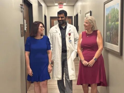 Two women walking with a doctor