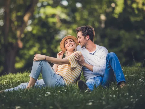 Happy couple relaxing in nature, promoting emotional well-being and stress relief through outdoor time and connection.