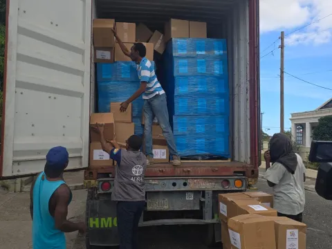 Workers unload supplies from a semitruck in Jamaica.