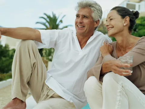A senior couple, sitting and relaxing, drinking water together.