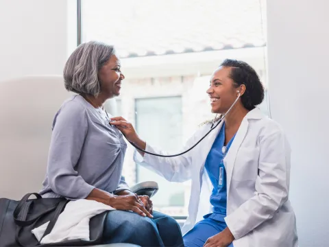Doctor listens to patient with stethoscope.