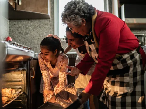 Grandmother, Mother and Child looking into an oven.