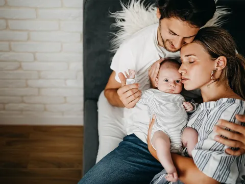 A Mother and Father Hug Their Newborn Baby