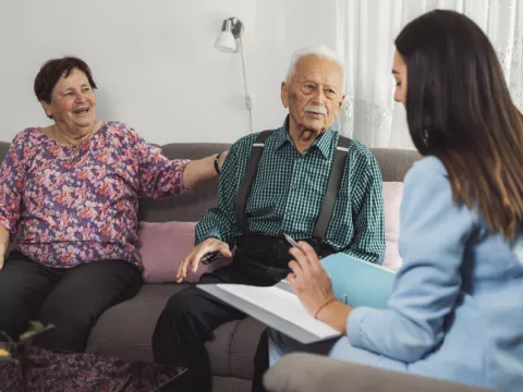 caregiver with eldery couple at home 