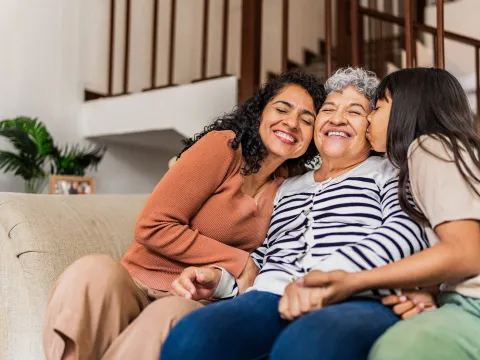 A multi-generational family sitting on the couch together.