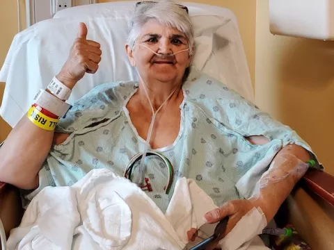 Patient Carol Dunn giving a thumbs up after her surgery.