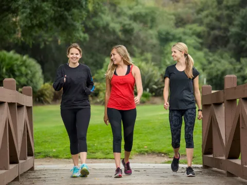 Three women in their 30s enjoy their morning walk.